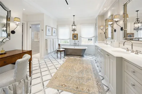 a large bathroom with a tub sink and mirror