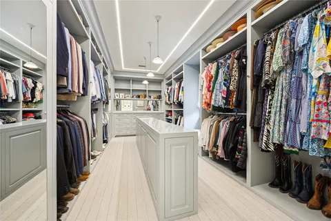 a view of walk in closet with clothes and shoes