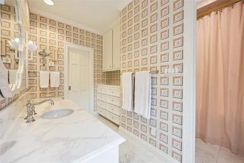 a bathroom with a granite countertop sink a mirror and shower