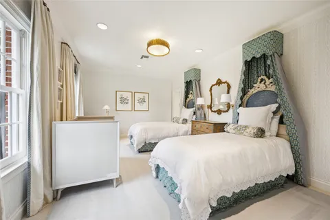 a bedroom with two beds and a window