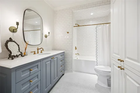 a bathroom with a double vanity sink toilet and shower
