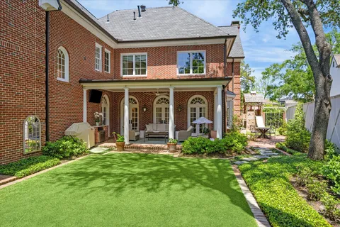 a view of a brick house with a yard and plants