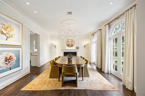 a dining room with wooden floor a glass table and chairs
