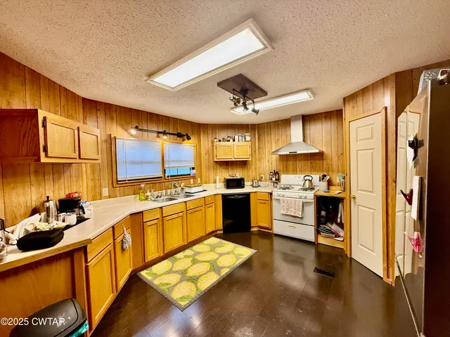 a large kitchen with a large window and stainless steel appliances