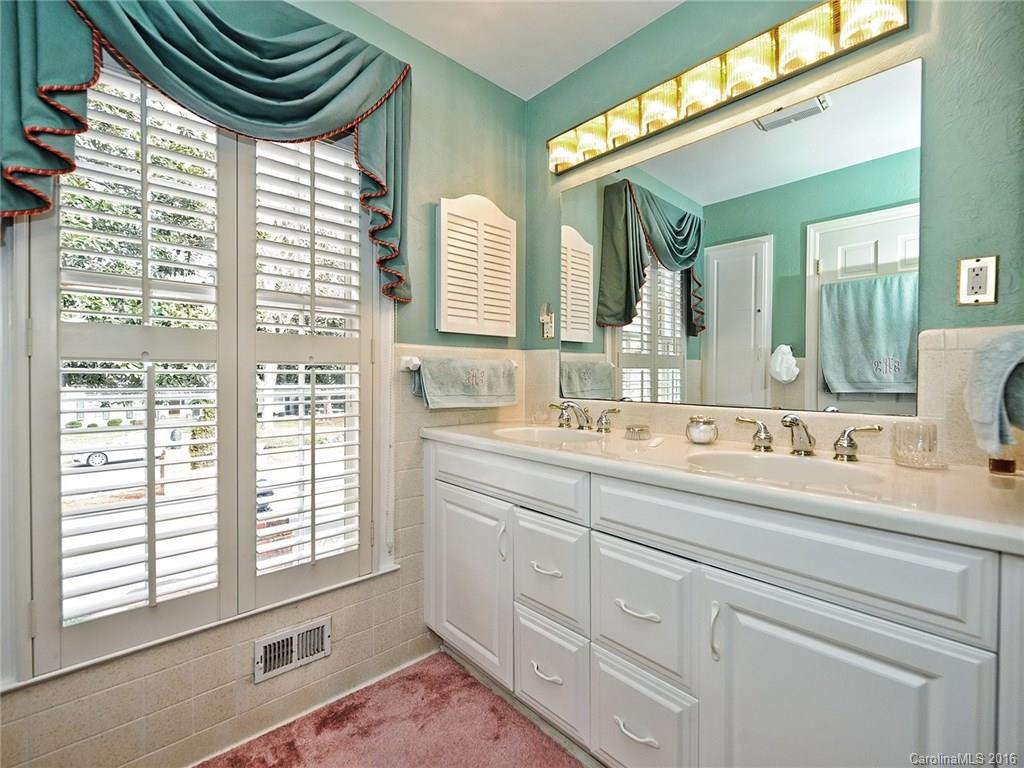 3123 Cloverfield Road Charlotte, NC 28211 - Photo 13 of 24 a bathroom with a sink a mirror and a bathtub next to a window