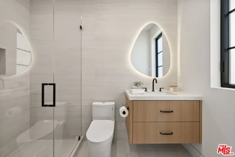a bathroom with a toilet a sink and mirror