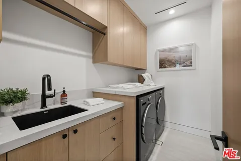 a utility room with sink dryer and washer
