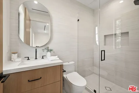 a bathroom with a sink toilet vanity and shower