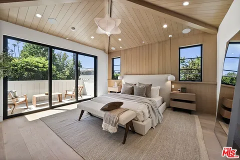 a spacious bedroom with a bed and a large window