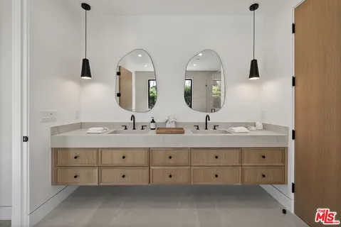 a bathroom with double sink and a mirror