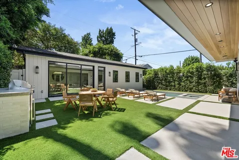 a view of a house with backyard sitting area and garden