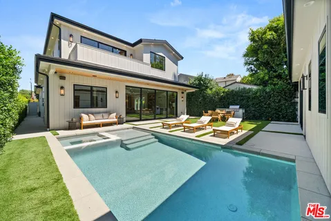 a view of an house with swimming pool and chairs