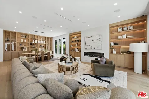 a living room with furniture kitchen view and a large window
