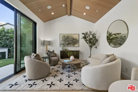 a living room with furniture a large window and a potted plant