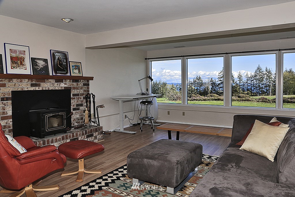 1835 Lancaster Road Freeland, WA 98249 - Photo 18 of 25 a living room with furniture a large window and a fireplace