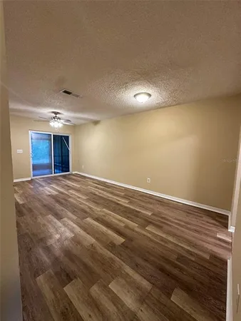 a view of empty room with wooden floor