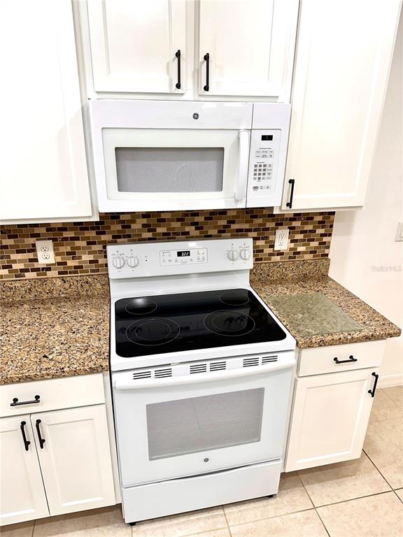 447 Pinecrest Loop Davenport, FL 33837 - Photo 13 of 23 a stove top oven sitting inside of a kitchen
