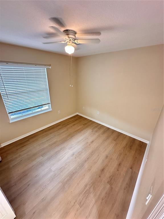 447 Pinecrest Loop Davenport, FL 33837 - Photo 19 of 23 a view of a room with wooden floor and fan