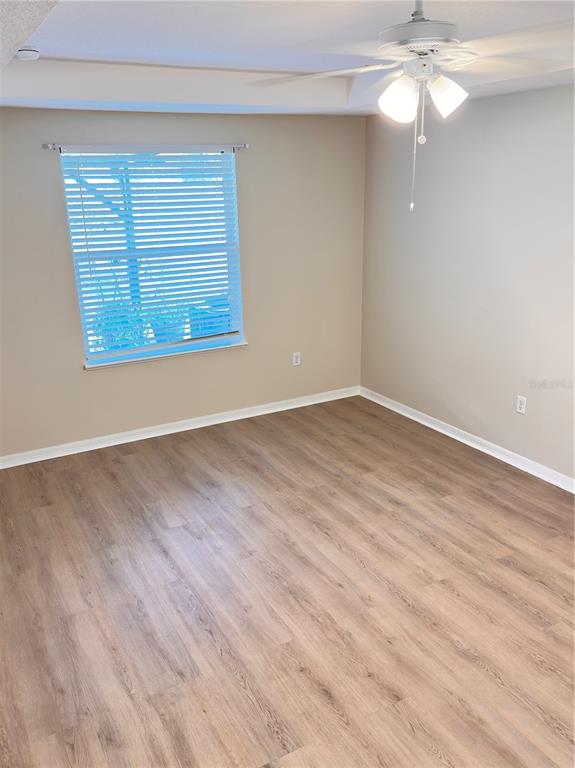 447 Pinecrest Loop Davenport, FL 33837 - Photo 20 of 23 a view of an empty room with wooden floor and a window