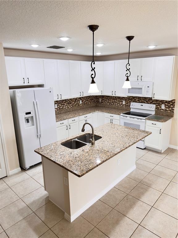 447 Pinecrest Loop Davenport, FL 33837 - Photo 7 of 23 a kitchen with stainless steel appliances granite countertop a sink a counter top space and cabinets