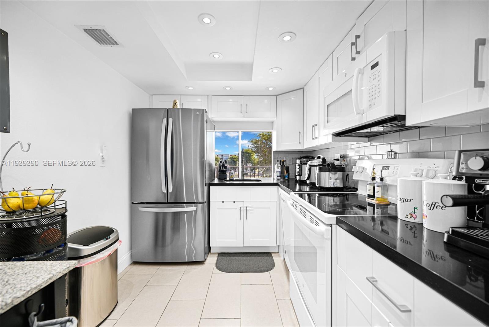 9441 Southwest 4th Street, Unit 309 Miami, FL 33174 - Photo 12 of 44 a kitchen with a sink stainless steel appliances and white cabinets