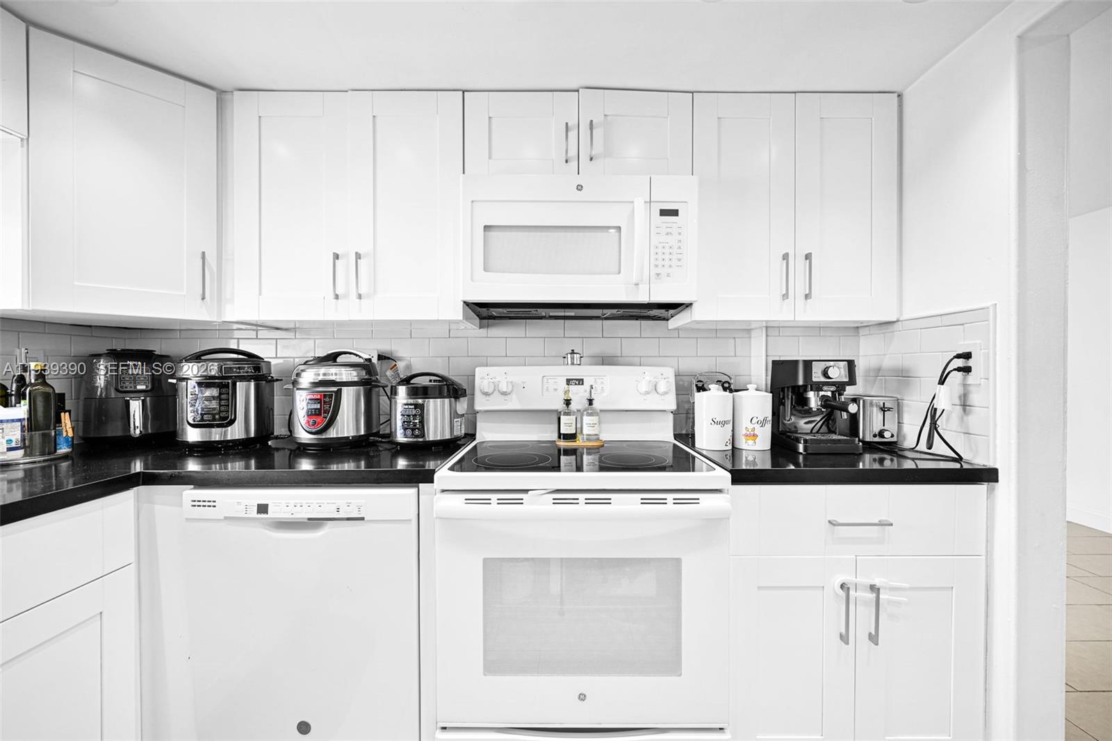 9441 Southwest 4th Street, Unit 309 Miami, FL 33174 - Photo 14 of 44 a kitchen with stainless steel appliances granite countertop a sink a stove and white cabinets