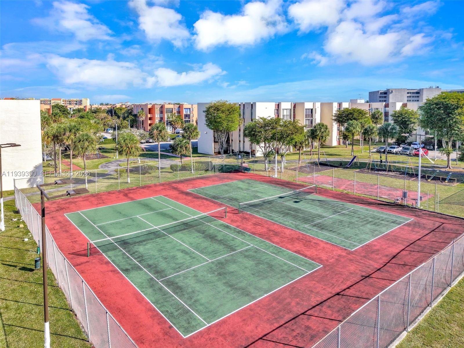 9441 Southwest 4th Street, Unit 309 Miami, FL 33174 - Photo 37 of 44 a view of a tennis ground with large trees