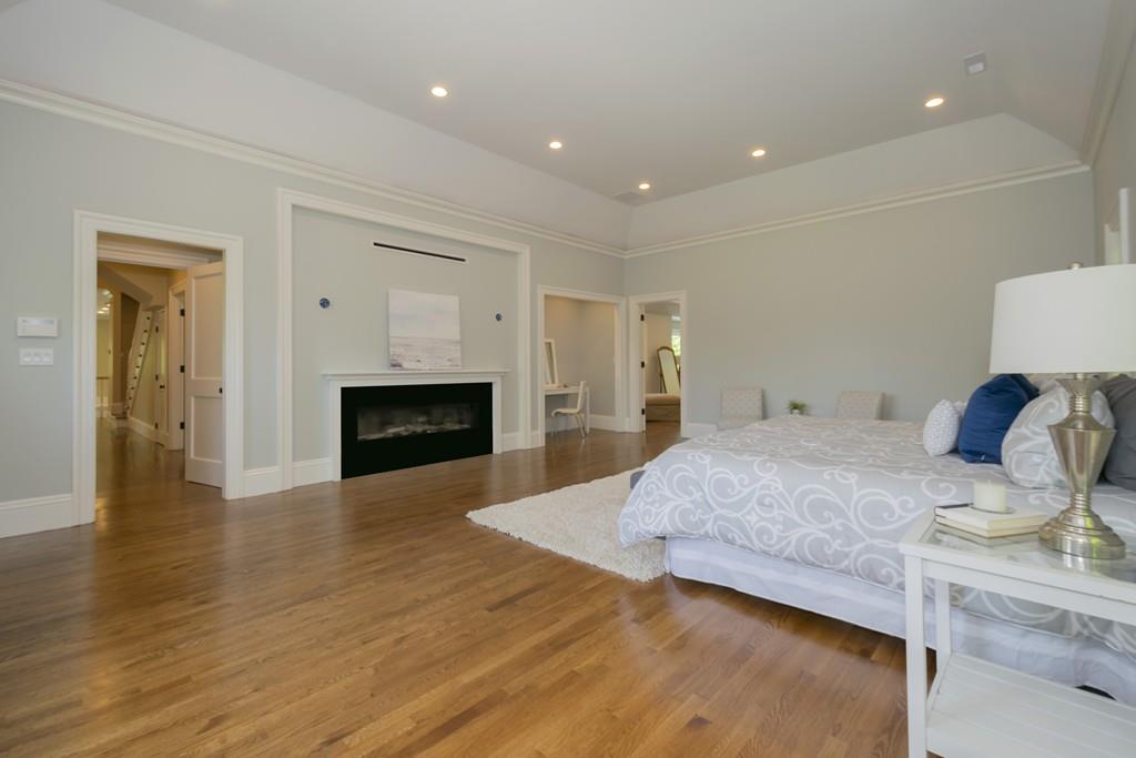 291 Emerson Road Lexington, MA 02420 - Photo 28 of 42 a spacious bedroom with a bed and a fireplace
