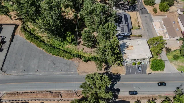 an aerial view of a house with a yard and large tree