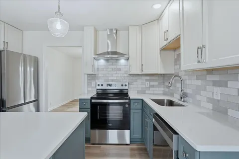 a kitchen with stainless steel appliances granite countertop a sink stove and refrigerator