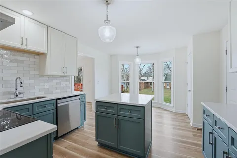 a kitchen with granite countertop a sink cabinets and wooden floor
