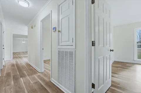 a view of a hallway with wooden floor and staircase