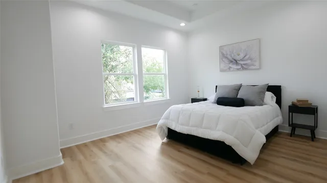 a large bed sitting in a bedroom next to a window