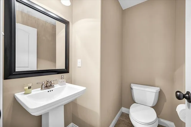 a bathroom with a toilet a sink and mirror