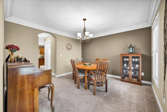 a dining room with furniture a chandelier and window