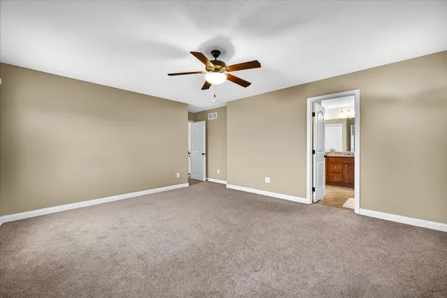 an empty room with closet and a ceiling fan