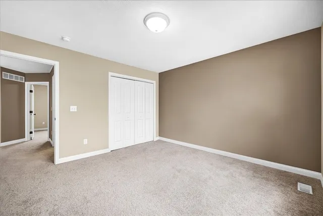 an empty room with closet and windows