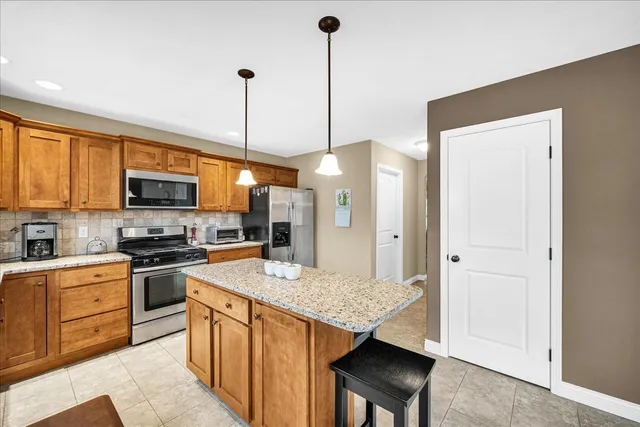 a kitchen with stainless steel appliances granite countertop a stove refrigerator sink and microwave