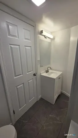 a bathroom with a sink a toilet and mirror