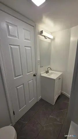 a bathroom with a sink a toilet and mirror
