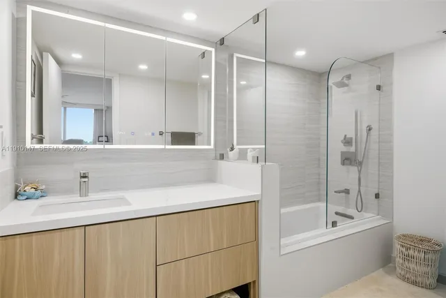 a bathroom with a bathtub shower sink vanity and toilet