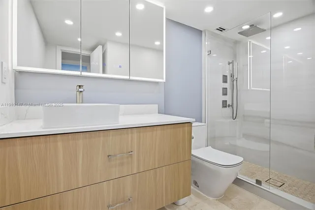 a bathroom with a sink a toilet and shower