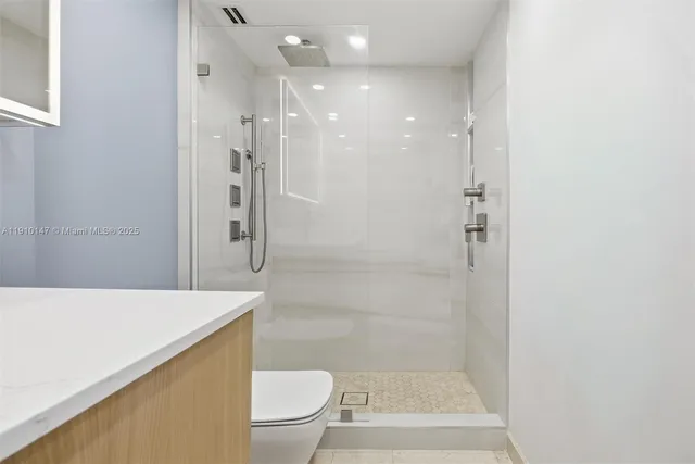 a bathroom with a shower a toilet and a sink