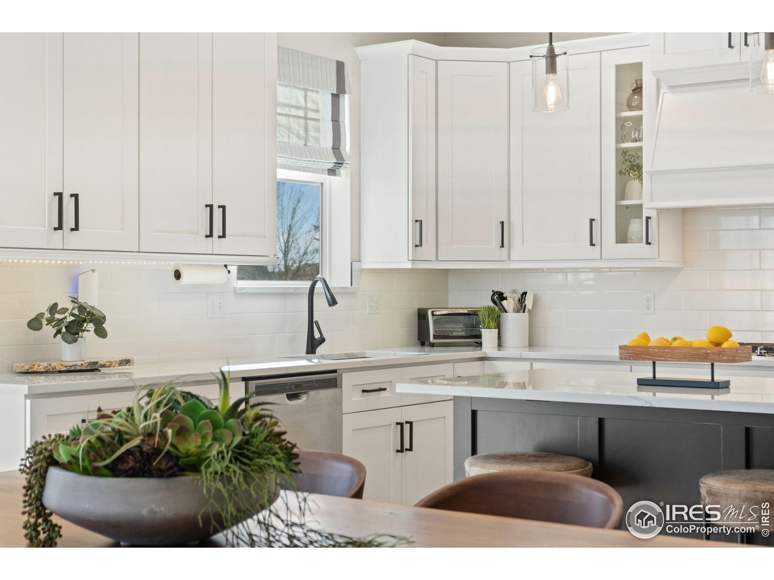 2032 Cuda Court Berthoud, CO 80513 - Photo 12 of 38 a kitchen with stainless steel appliances kitchen island granite countertop a sink a stove white cabinets and a granite counter tops
