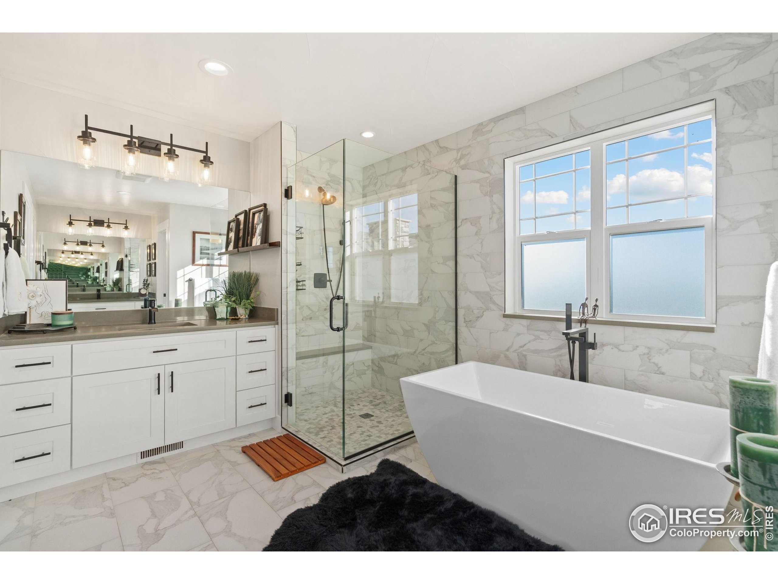 2032 Cuda Court Berthoud, CO 80513 - Photo 23 of 38 a spacious bathroom with a shower sink and mirror
