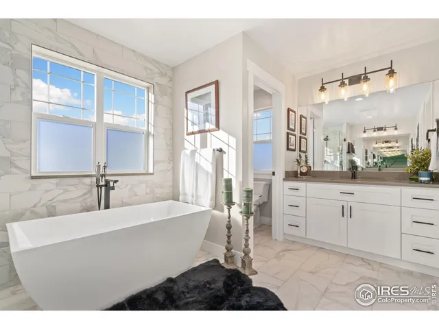 a bathroom with a sink tub double vanity and mirror