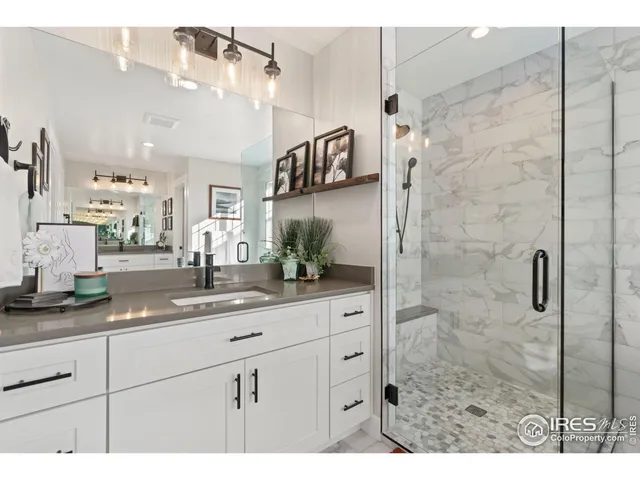 a bathroom with a granite countertop sink mirror and shower