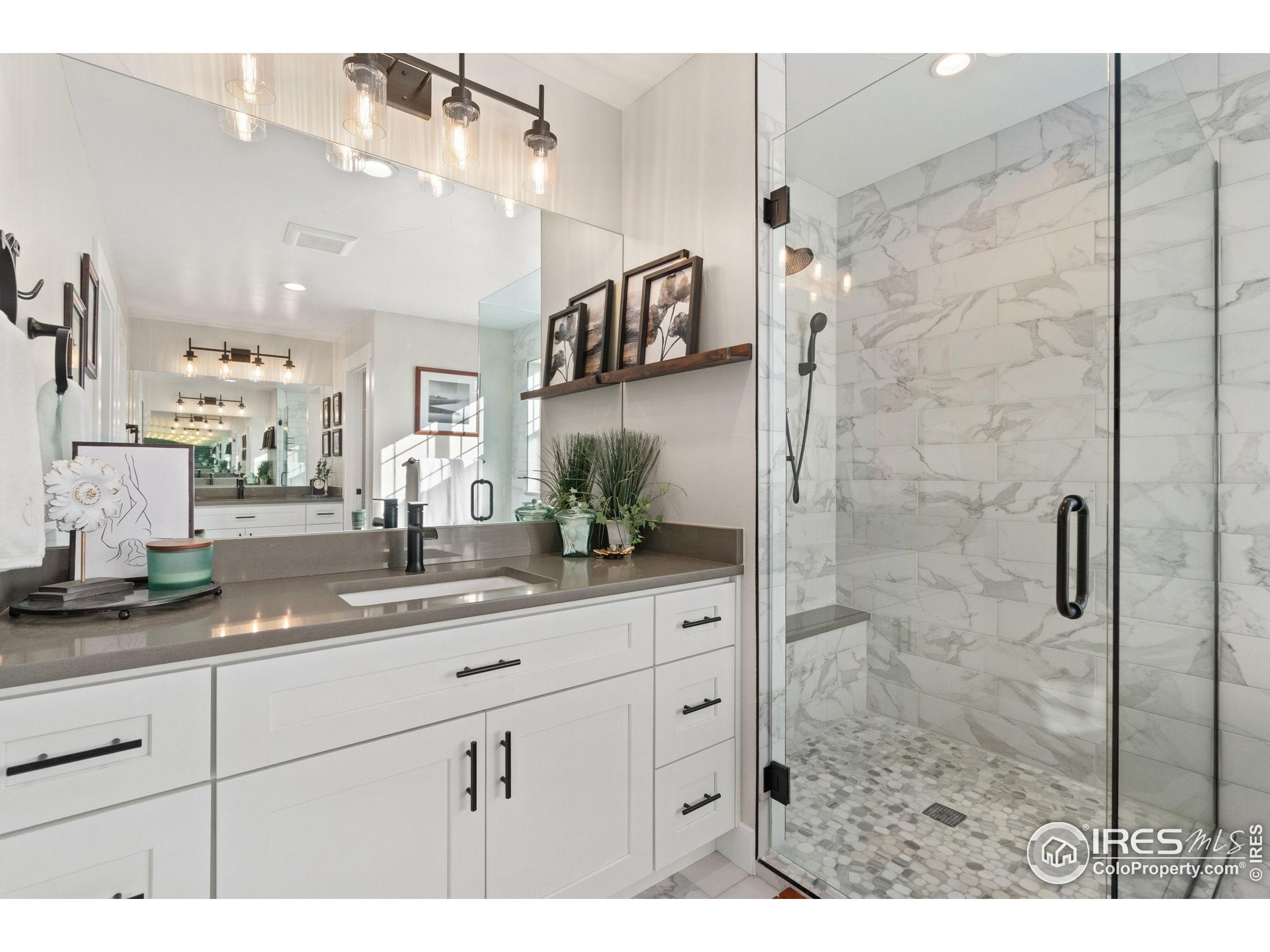2032 Cuda Court Berthoud, CO 80513 - Photo 25 of 38 a bathroom with a granite countertop sink mirror and shower