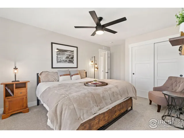 a bed room with a bed a chair and potted plant