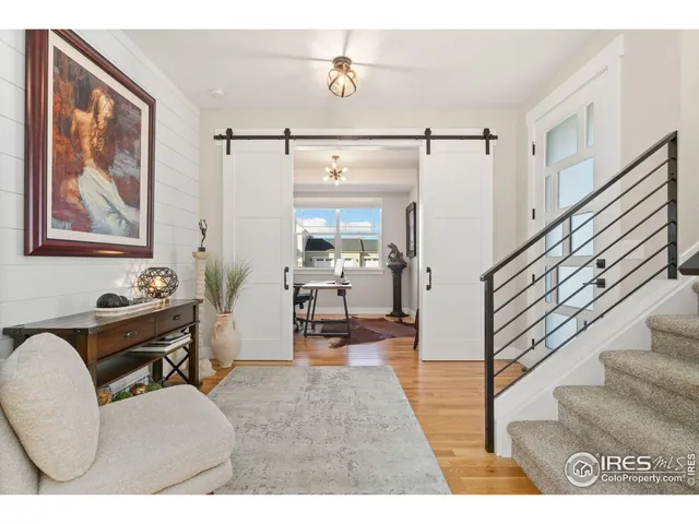 a living room with furniture and a dining table with wooden floor